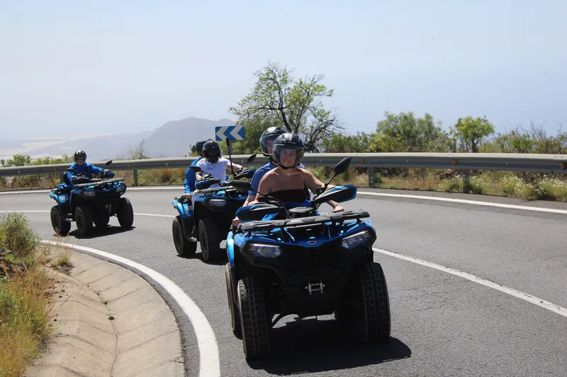 Riders driving quad bikes through forest road on Mount Teide excursion